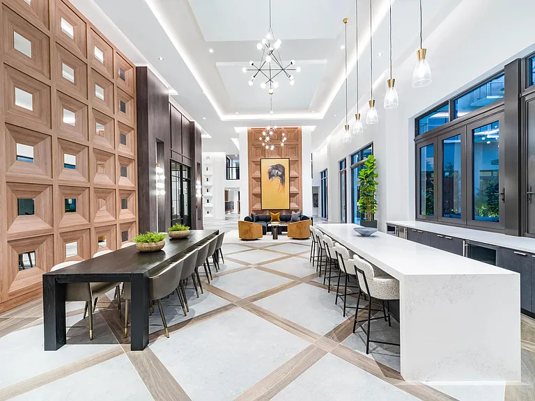 A light-filled gathering space at Modera Aventura, where layered wood, sculptural lighting, and open seating reflect a polished, coastal-inspired design.