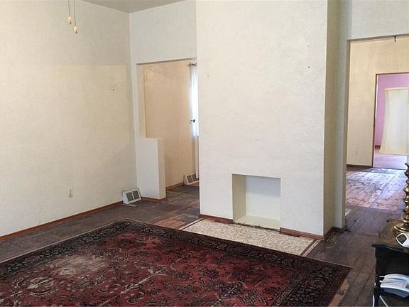 Living room with high ceilings/ceiling fan and fireplace.