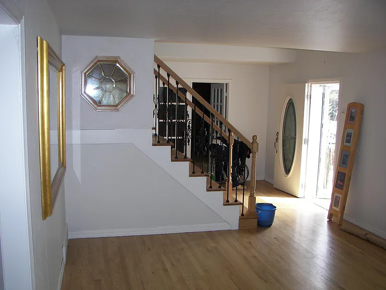 Living room looking toward front door, stairs, and library w