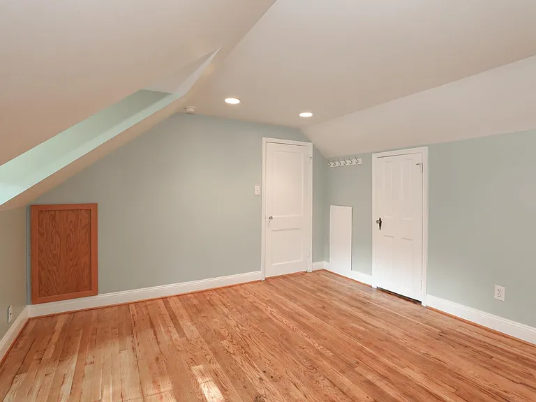 Upper bedroom with sloped ceilings and closet door.
