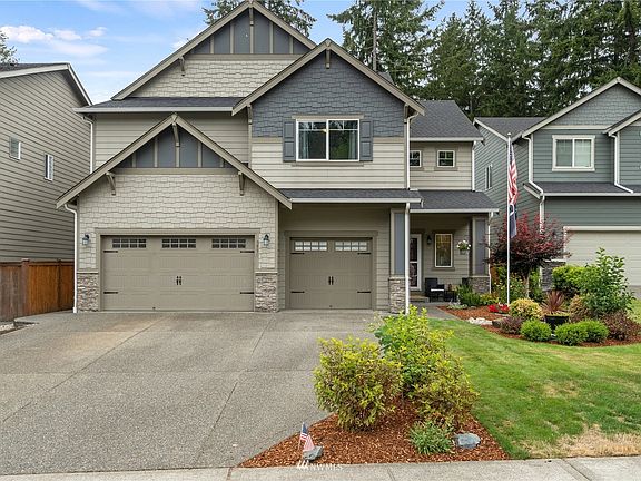 3 car garage, architectural details, stone accent, flag pole, concrete walkway to the back of home and fantastic curb appeal!