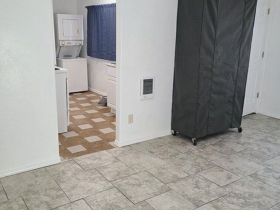 Living room looking into kitchen with closet on wheels