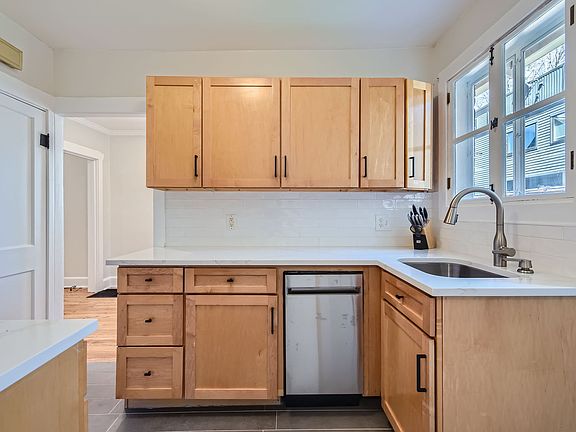 Brand new kitchen with stainless steel appliances (dishwasher, refrigerator, and microwave)
