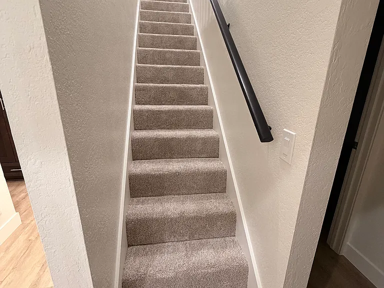 Stairs leading to upstairs loft style primary bedroom