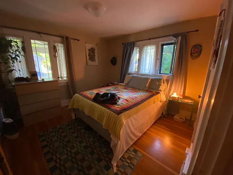 April 2025-Front bedroom with two large windows and functioning screens. This bedroom faces the front porch