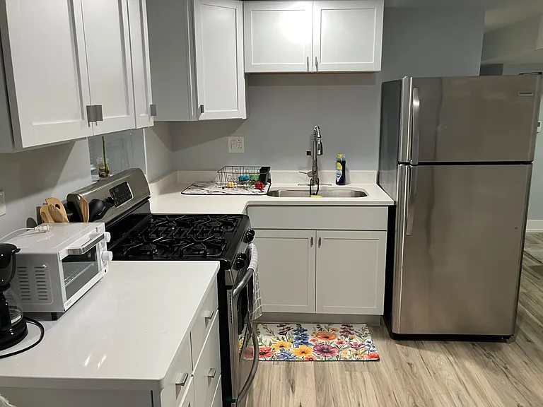Efficient kitchen with ample white cabinetry, generous counter space, stainless fridge, and a gas range for everyday cooking.