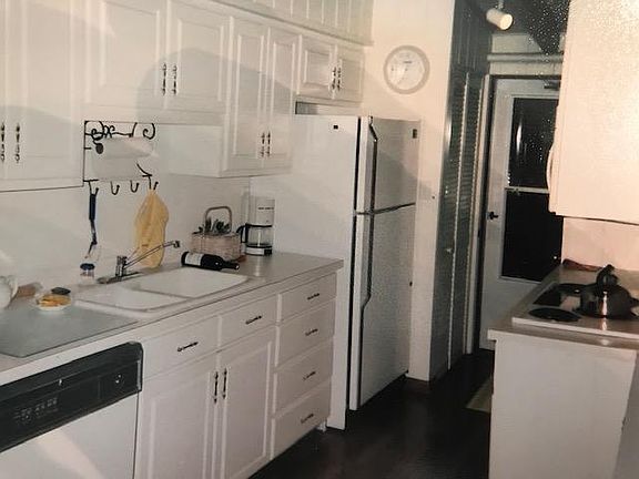 Galley kitchen connects to laundry area.