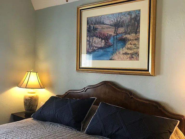 King sized bed, with two side tables and lamps.