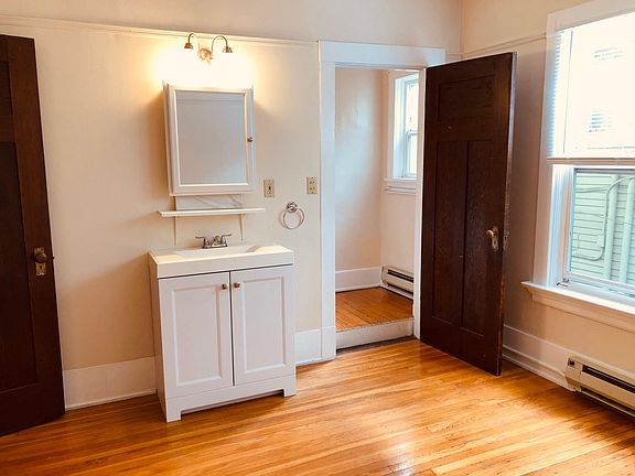 New vanity conveniently located in the bedroom. Original paneled wood doors add character.