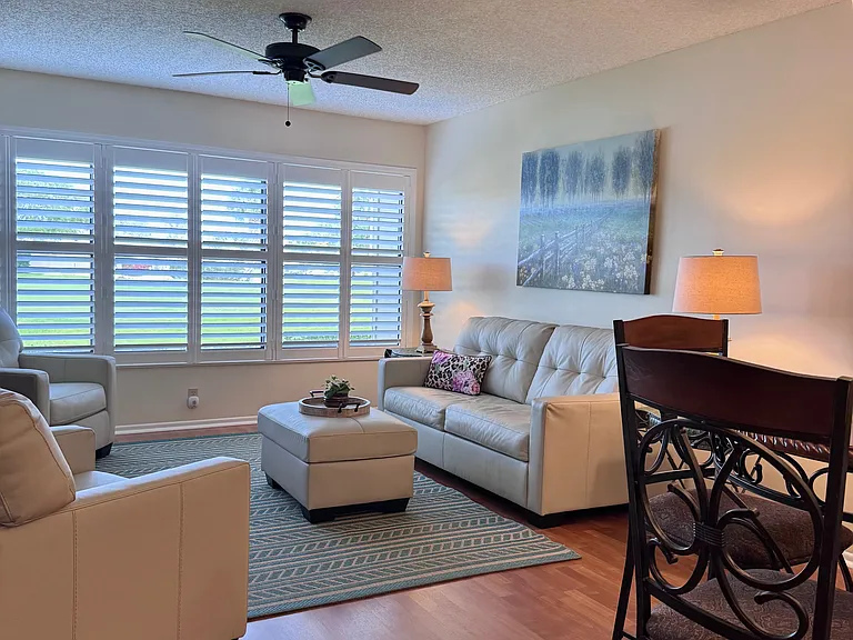 Beautiful living area w/ plantation shutters & gorgeous lake & golf course views!