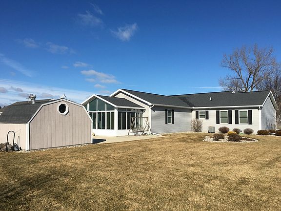 A view of the back of the house, it comes with a long paved driveway and shed. Sit back in your 4 seasons room and enjoy the up and coming beautiful weather and do some grilling.
