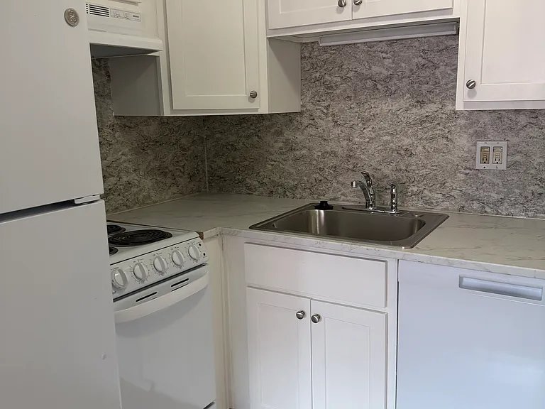 kitchen has white cabinets, fridge, dishwasher and electric stove