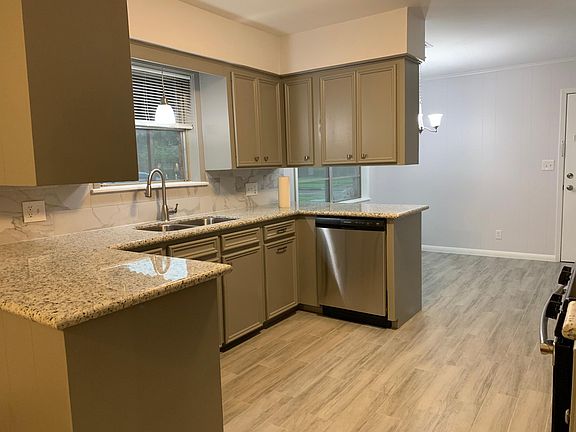 View of kitchen from the family room. Wrap-around bar with granite countertops