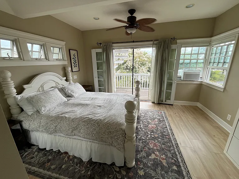 Master Bedroom on second floor. Deck outside leads up to rooftop deck with ocean view. It has AC in the window, rarely needed because of the open, breezy nature of the room.