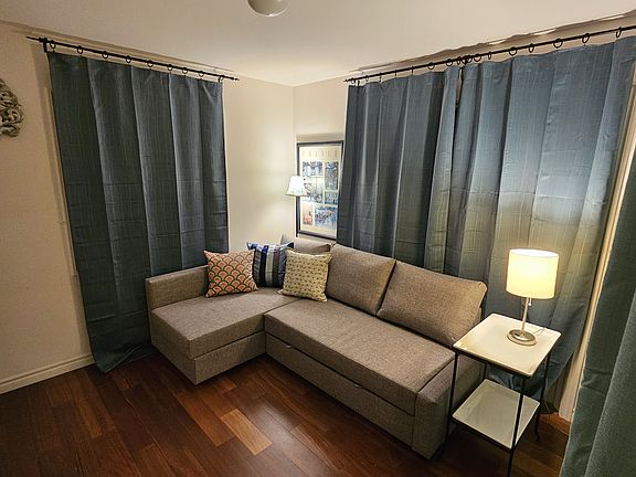 Bedroom with sofa/bed, closet and additional storage and blackout curtains