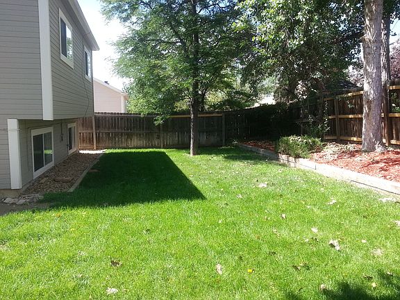 The backyard provides a great lawn and large trees.