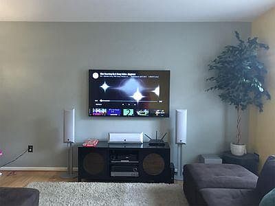 Large living room area that can host a spacious sofa, console, speakers, and huge wall-mounted big-screen TV.