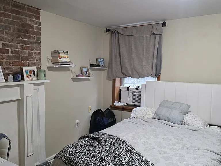 Bedroom 1 with exposed brick and mantle pic 1