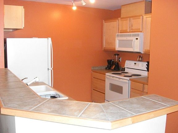 Spacious kitchen w/ tile countertop breakfast bar and plenty of cabinet space.