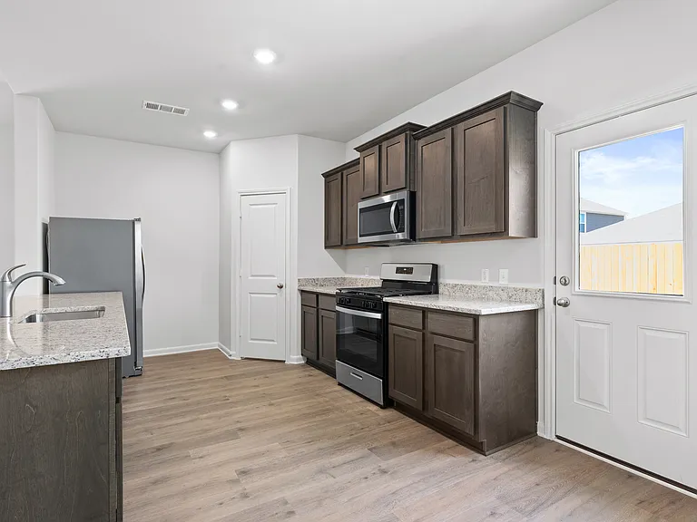 The kitchen has designer wood cabinetry.