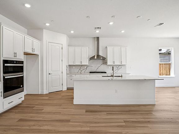 Kitchen with large central island and full slab backsplash