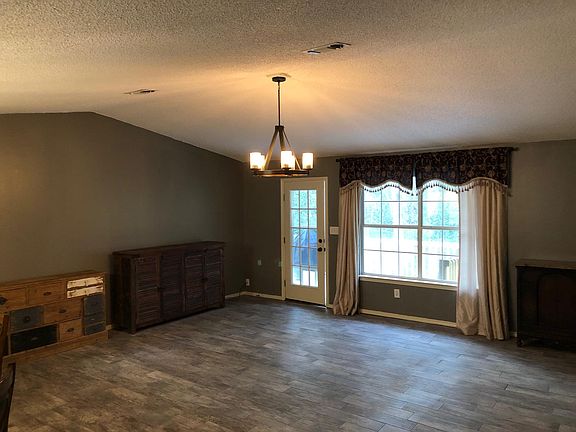 Large den with Faux wood file, updated bronze light fixture vaulted ceiling