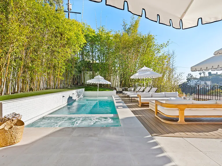 Luxury poolside seating, crisp umbrellas, and lush bamboo for total privacy.