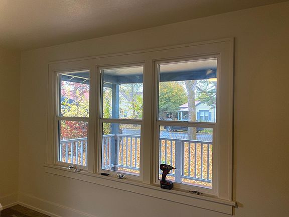 Living Rooms Windows with View of 2nd Avenue East Curtains with sheers to be installed by landlord prior to move in.