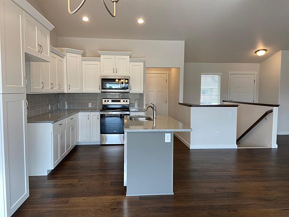 Pantry cabinet is on the left. This kitchen now has a stainless steel, french door refrigerator with an icemaker. The hallway (to the right of the oven) goes to the laundry room (on the left) and the two-car, oversized garage. The stairway goes to the