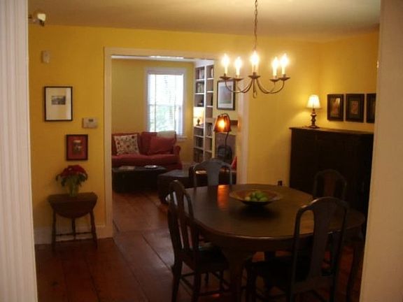 Open living room and dining room layout with historic wide pine floors