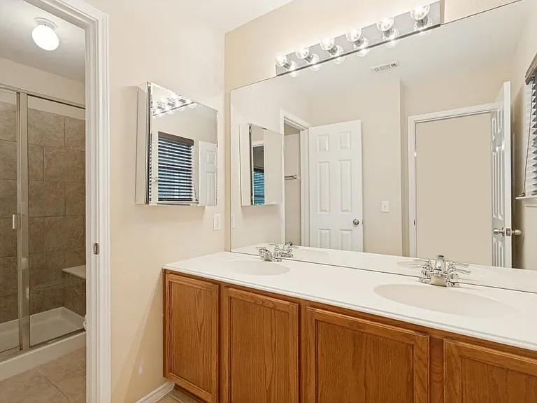 Primary bath with shower and dual sinks.