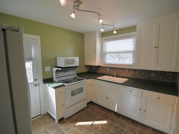 Kitchen. Door to outside and fenced in yard.