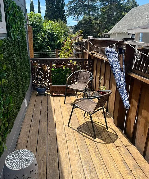 Enclosed private deck with chairs, umrbrella and tables.