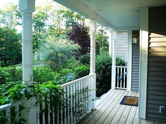 Charming covered front porch overlooks sweeping front lawn