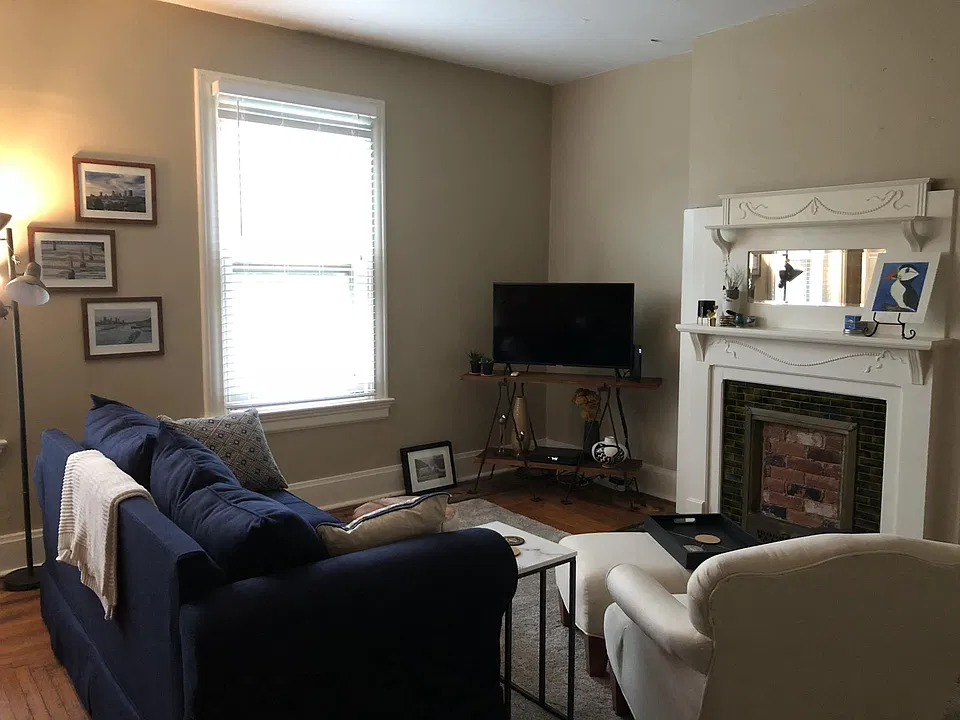 Apt 3 - living room - view 1 - 2 large windows, hardwood floors and decorative fireplace