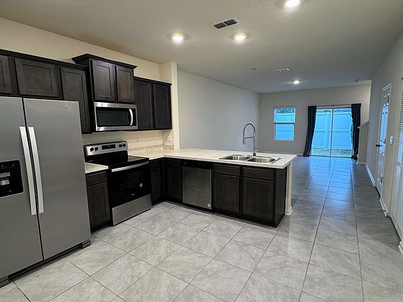 Open kitchen/living room area. View from near the garage door entryway.