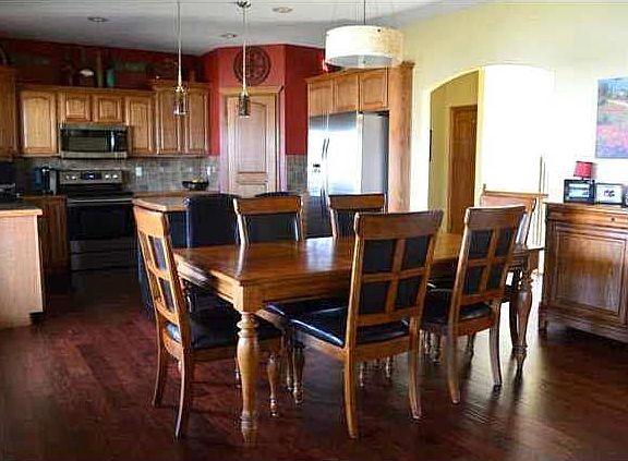 Open concept dining room and kitchen with wood floors.
