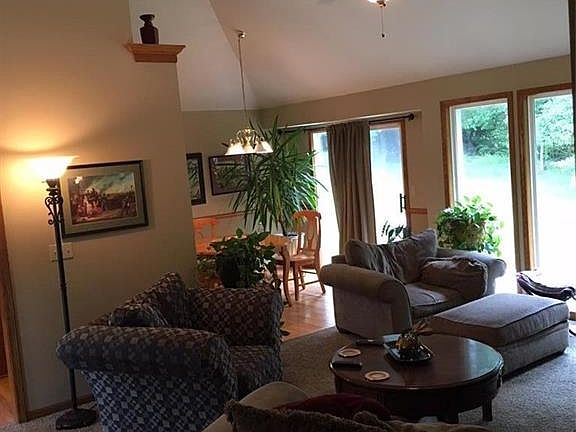 Main living room and dining room with large windows and vaulted ceilings