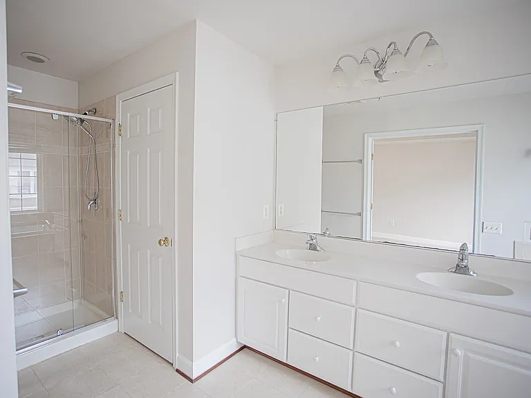 Double vanities, lots of storage, oversized mirror, toilet tucked behind a separate door for privacy