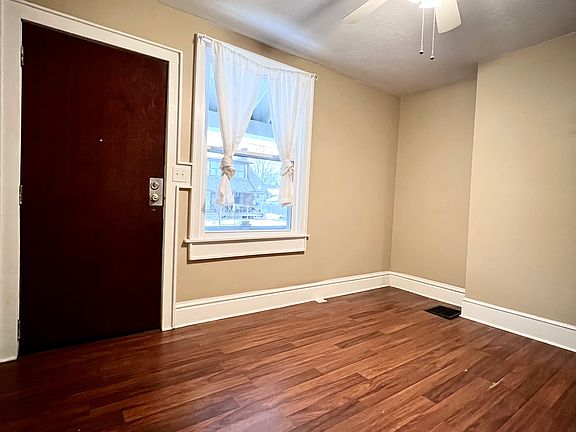Front door entry into living room featuring high ceiling