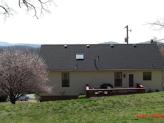 back of the house with a view of rolling hills