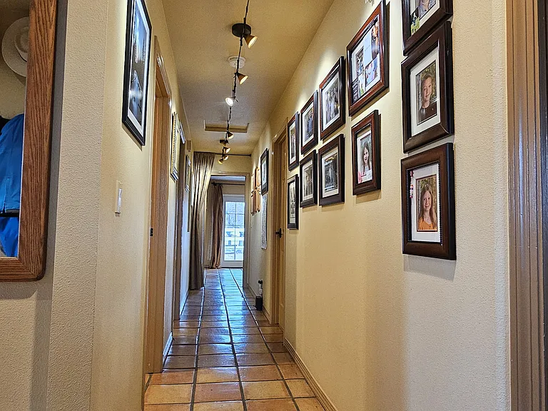 Hallway from front door entrance goes down to private master suite area