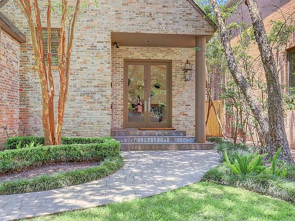 Beautiful walkway with crepe myrtles as you approach the double doors to enter the home.