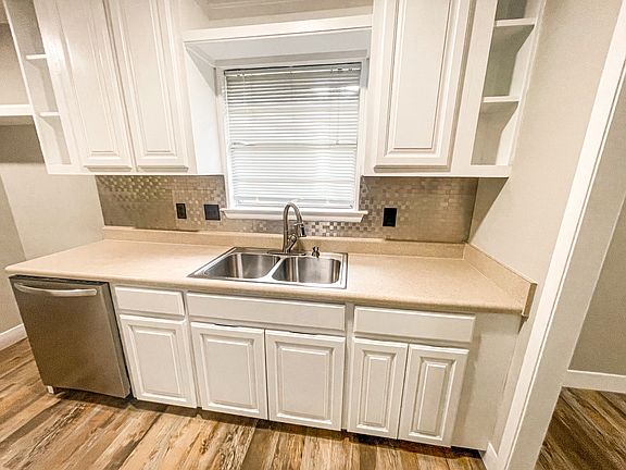 Kitchen area with deep sink and stylish backsplash.