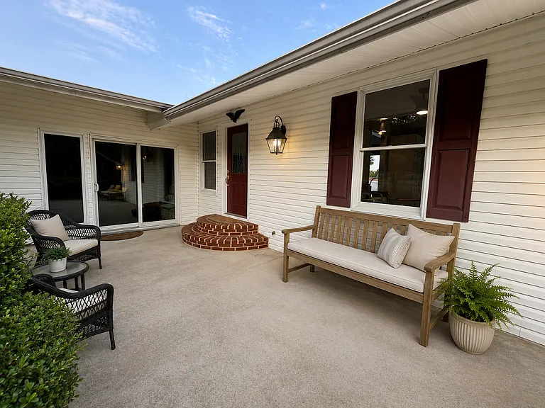 Welcoming front patio featuring a charming covered entry, spacious seating area, and direct access to the home_perfect for enjoying your morning coffee or relaxing outdoors.