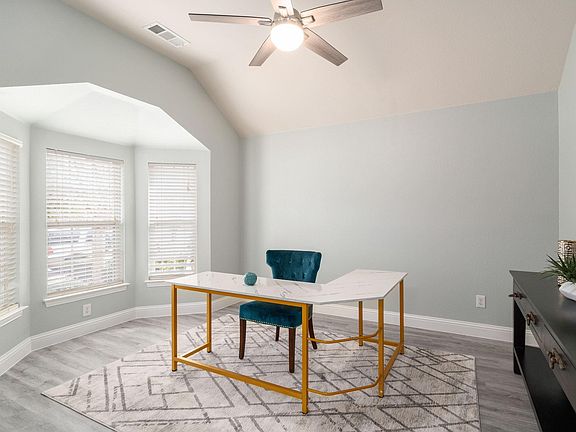 The private office boasts large windows and is enclosed by french doors.