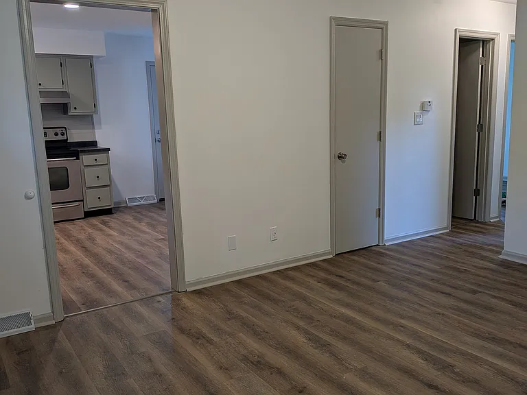 Living room (doorway to kitchen, closet, and bathroom door)