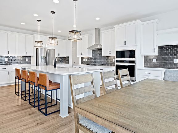Island kitchen and dining area in a DRB Homes Bridgeport model at the Prinland Heights community.