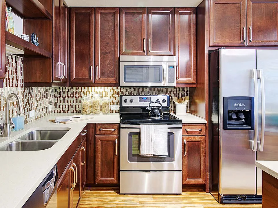 Griffis Uptown apartment kitchen with quartz countertops and stainless steel appliances.