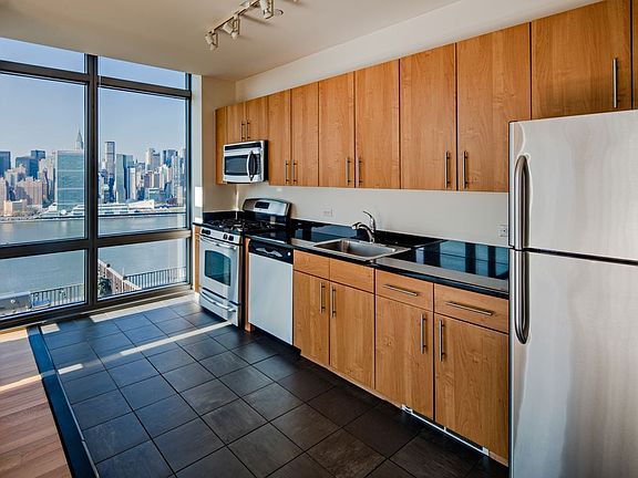 Classic Package III kitchen with stainless steel appliances, maple cabinetry, black granite countertops, and tile flooring
